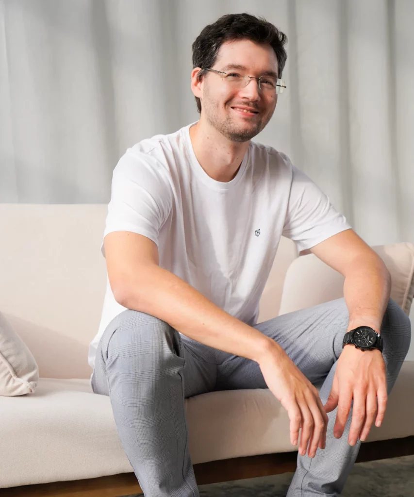 Tori Webdesign Gründer Stefan Lassen in heller Kleidung auf einer cremefarbenen Couch.