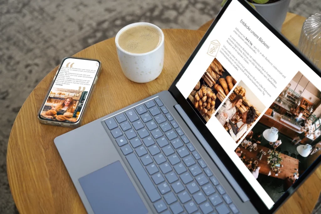 Laptop und Smartphone auf einem Kaffeetisch. Zeigt eine responsive Webseite.