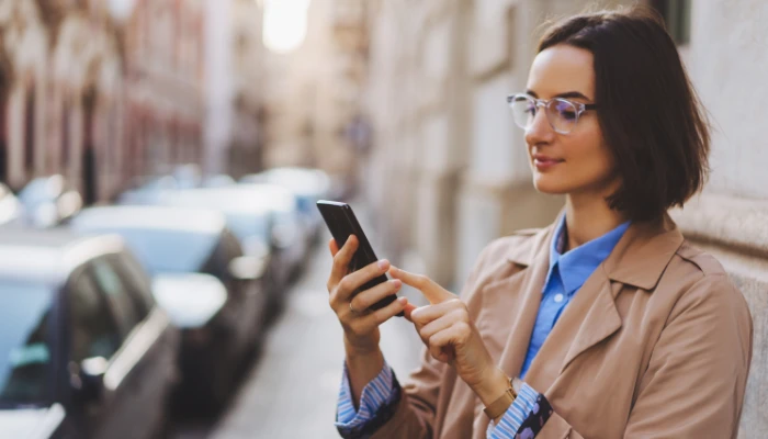 Junge Frau schaut sich auf dem Smartphone eine Webseite an